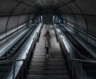 person-climbing-staircase-between-escalators